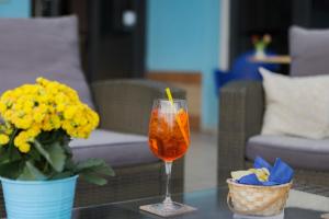 a drink in a glass on a table with flowers at Art Hotel La Perla in Bellaria-Igea Marina