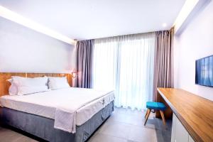 a hotel room with a bed and a television at Senso Suites in Nea Peramos