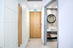 a bathroom with a wooden door and a sink at Senso Suites in Nea Peramos