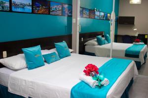 sypialnia z 2 łóżkami w kolorze niebieskim i białym w obiekcie SUITES FullHouse w mieście Guayaquil