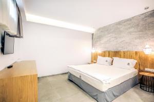 a hotel room with a bed and a tv at Senso Suites in Nea Peramos