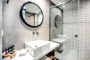 a bathroom with a sink and a mirror at Senso Suites in Nea Peramos