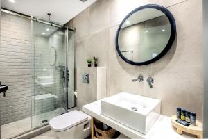 a bathroom with a toilet and a sink and a mirror at Senso Suites in Nea Peramos