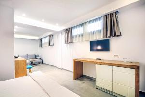a room with a desk and a couch at Senso Suites in Nea Peramos