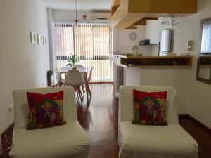 a living room with two chairs and a kitchen at Brisa del Rio in Rosario