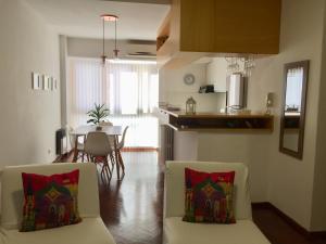 a living room with two chairs and a kitchen with a table at Brisa del Rio in Rosario