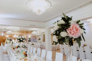 ein Zimmer mit Tischen, weißen Stühlen und Blumen in der Unterkunft Hotel Kruk in Smardzewice