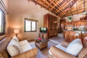 a living room with couches and a tv at Coco Beach Resort in San Pedro