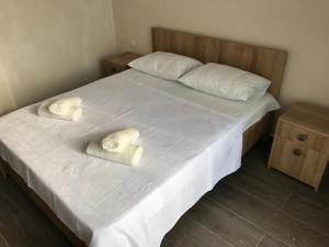 a bedroom with a bed with white sheets and pillows at Hotel CHARLI in Gonio