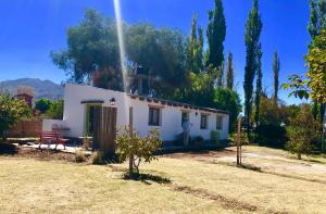 a small white house in a field with trees at Casa San José in Cachí