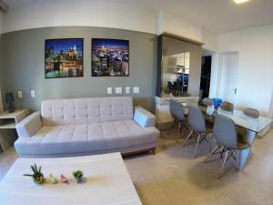 ein Wohnzimmer mit einem weißen Sofa und einem Tisch in der Unterkunft Apartamento família e com linda vista mar in Fortaleza