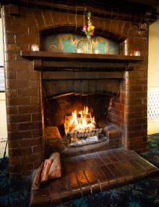 a fireplace with a fire burning inside of it at The Mile End Hotel in Adelaide
