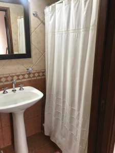 a bathroom with a white shower curtain and a sink at Departamento a 200 mts de la laguna in Chascomús