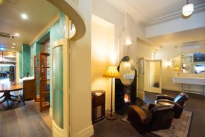 a living room with chairs and a table and a lamp at The Mile End Hotel in Adelaide