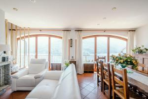 a living room with white furniture and large windows at Villa Fantastica in Carate Urio