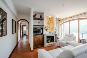 a living room with a couch and a fireplace at Villa Fantastica in Carate Urio