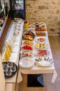 a long table with many plates of food on it at Boutique Room Kaliopi in Hvar