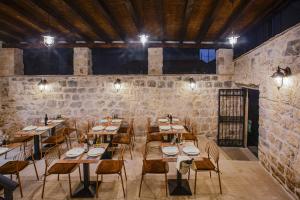 a restaurant with wooden tables and chairs and a brick wall at Boutique Room Kaliopi in Hvar