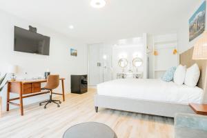 a bedroom with a bed and a desk and a computer at The Belmont Shore Inn in Long Beach