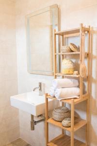 łazienka z umywalką i półką z ręcznikami w obiekcie Villa Lele - peace, mountain & sea view, heated pool w mieście Novigrad