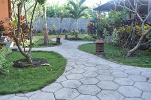 a walkway in a garden with trees and plants at Made Taro - Menjangan Homestay in Banyuwedang