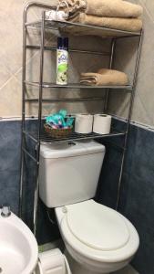 een badkamer met een toilet en een plank met handdoeken bij marazul in San Antonio de Padua