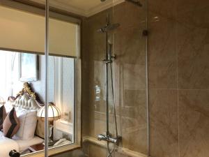 La salle de bains est pourvue d'une douche avec une porte en verre. dans l'établissement Hoang Nham Luxury Hotel, à Ta Lan Than