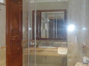 a bathroom with a sink and a mirror at Hoang Nham Luxury Hotel in Ta Lan Than
