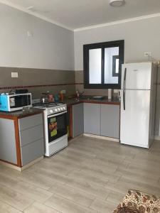 查斯科穆斯Departamento en Chascomús a dos cuadras de laguna的厨房配有白色冰箱和炉灶