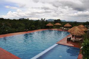 una gran piscina con sillas y sombrillas en Memoria Palace & Resort en Pailin