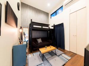 福岡的住宿－TRIP POD KOMONDO-MACHI，客厅配有双层床和桌子