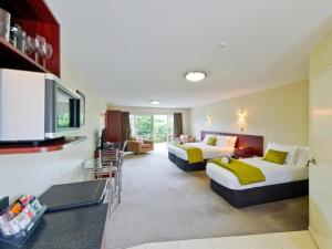 a hotel room with two beds and a living room at ASURE Avenue Motor Lodge in Timaru