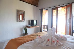 a bedroom with a bed with white towels on it at Dayuh House in Nusa Penida