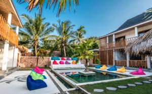 a pool in the backyard of a villa with colorful pillows at Kaniu Capsule Hostel in Kuta Lombok