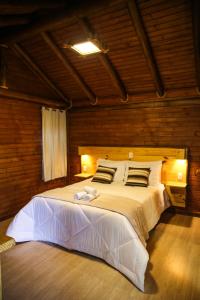 sypialnia z dużym białym łóżkiem w pokoju w obiekcie Pousada Morada da Serra w mieście Cambará