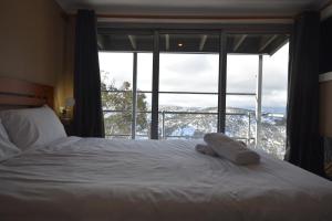 a bedroom with a bed and a large window at Fountains 18 in Mount Hotham