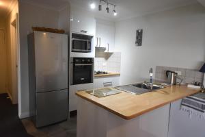 a kitchen with a refrigerator and a wooden counter top at Fountains 18 in Mount Hotham