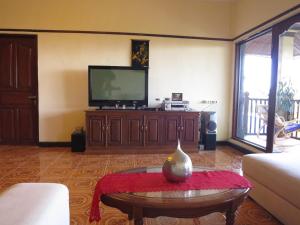 a living room with a tv and a coffee table at Mountain View House in Kintamani
