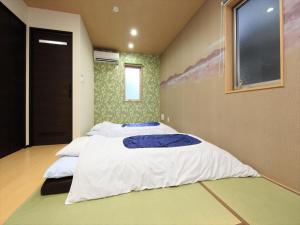 COTO Tokyo Nakano tesisinde bir odada yatak veya yataklar