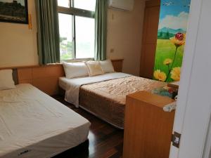 una stanza con due letti e un dipinto sul muro di Love With Dolphin B&B a Magong