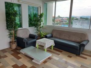 a living room with two couches and a coffee table at Baan Malee in Phuket Town
