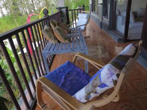 a rocking chair with pillows sitting on a porch at Mountain View House in Kintamani