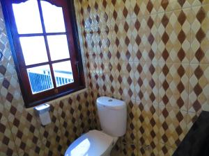een badkamer met een toilet en een raam bij Mountain View House in Kintamani