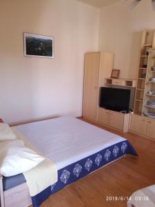 1 dormitorio pequeño con 1 cama y TV en Studio Bella, en Rovinj