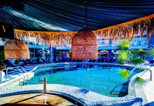 a large swimming pool in a building with a ceiling at Zornitsa Apart in Primorsko