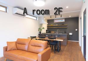 a room with a couch and a table and a kitchen at FLAG Zushi in Zushi