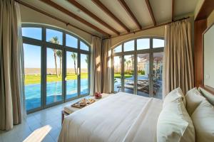 a bedroom with a large bed and large windows at FLC Luxury Resort Samson in Sầm Sơn