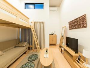 sala de estar con cama elevada y sofá en TRIP POD TAKASAGO B, en Fukuoka