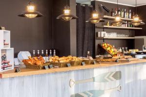 a counter with baskets of bread and other food at Best Western Plus Antibes Riviera in Antibes