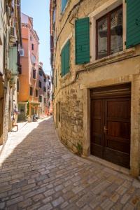 an alley with a wooden garage door on a building at Apartment Adriatico Eterno 2 in Rovinj